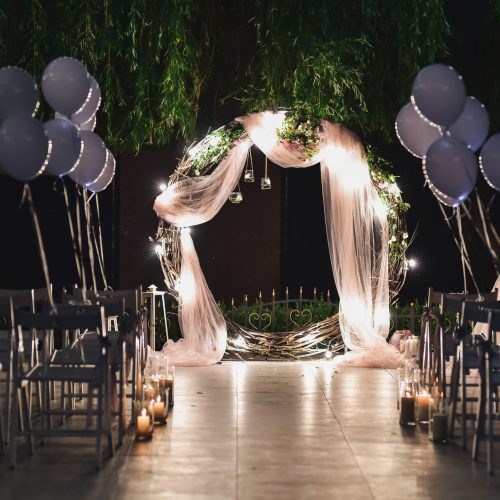 Shine wedding altar for newlyweds stands on the backyard decorated with balloons and greenery